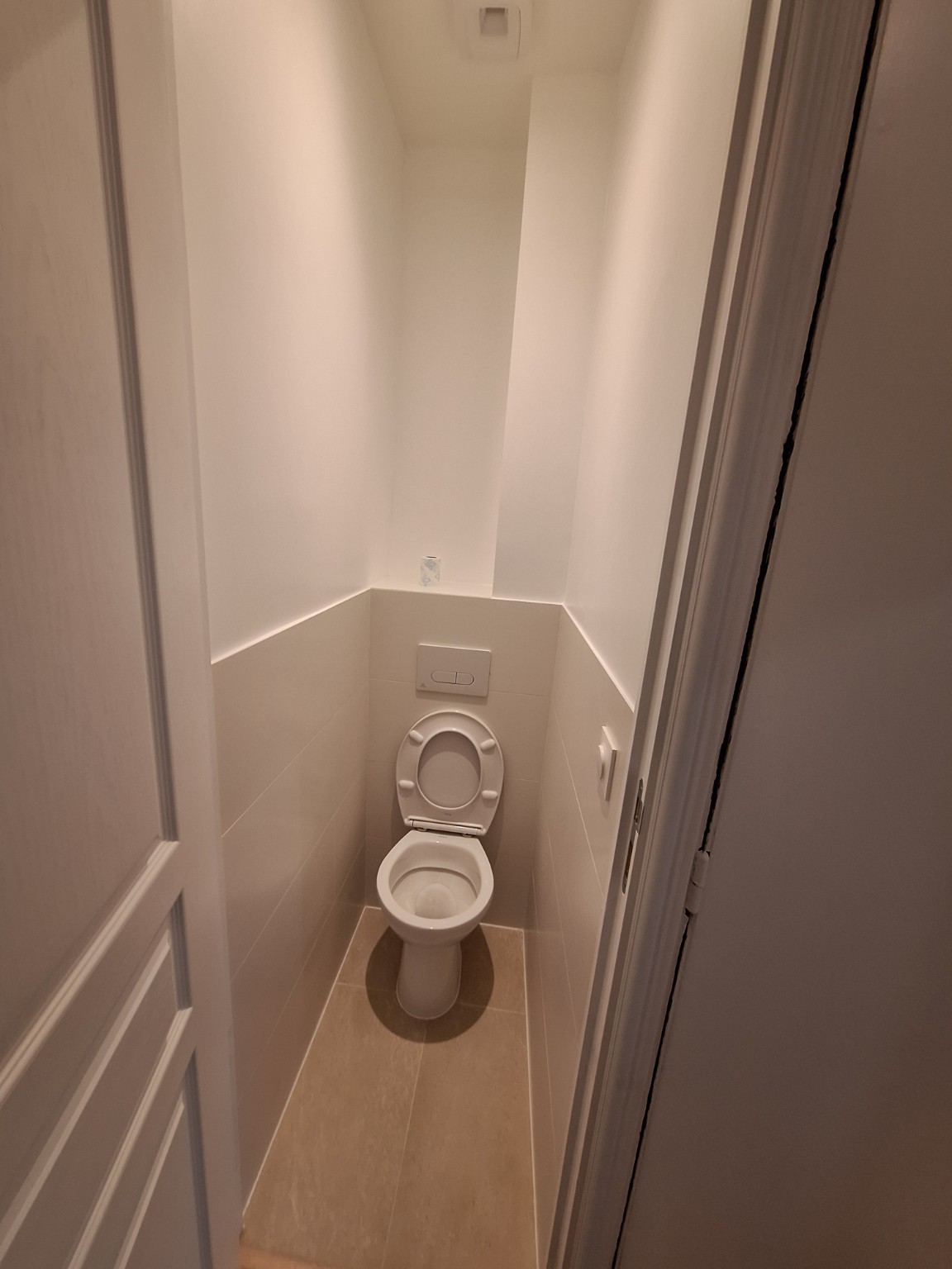 Toilettes rénovées avec carrelage beige