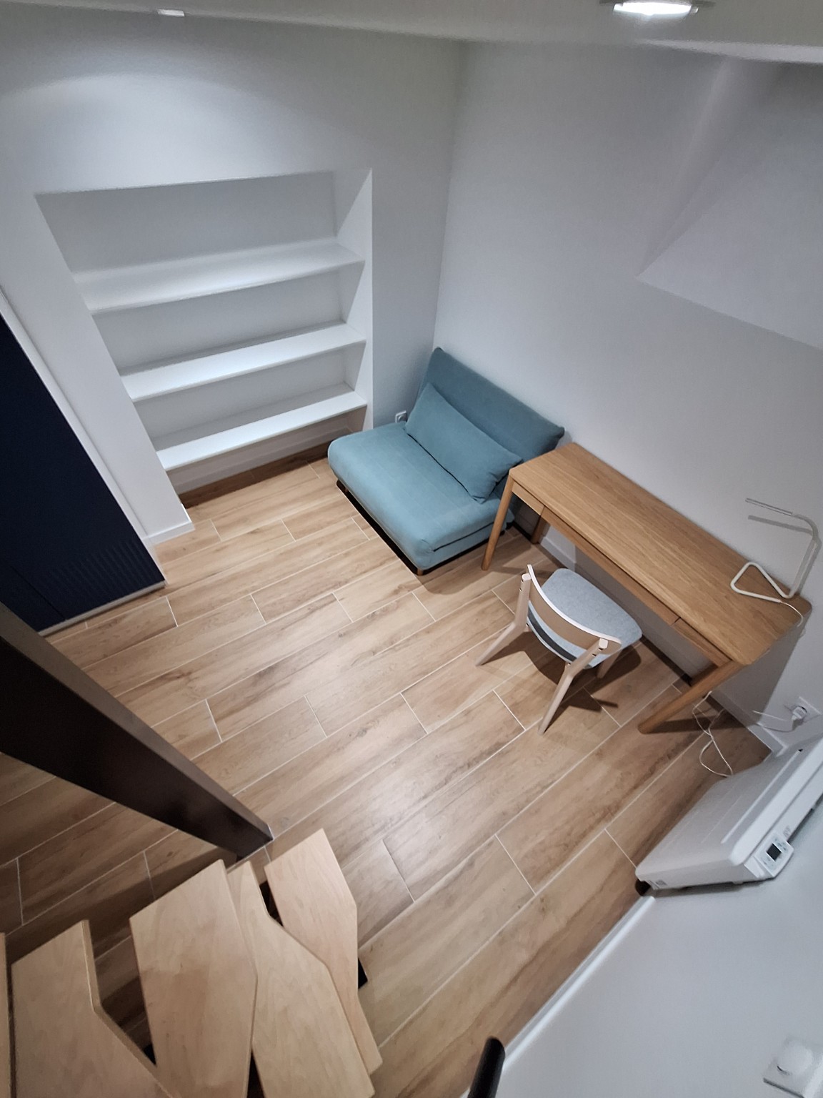 Pièce aménagée sous mezzanine avec rangements intégrés