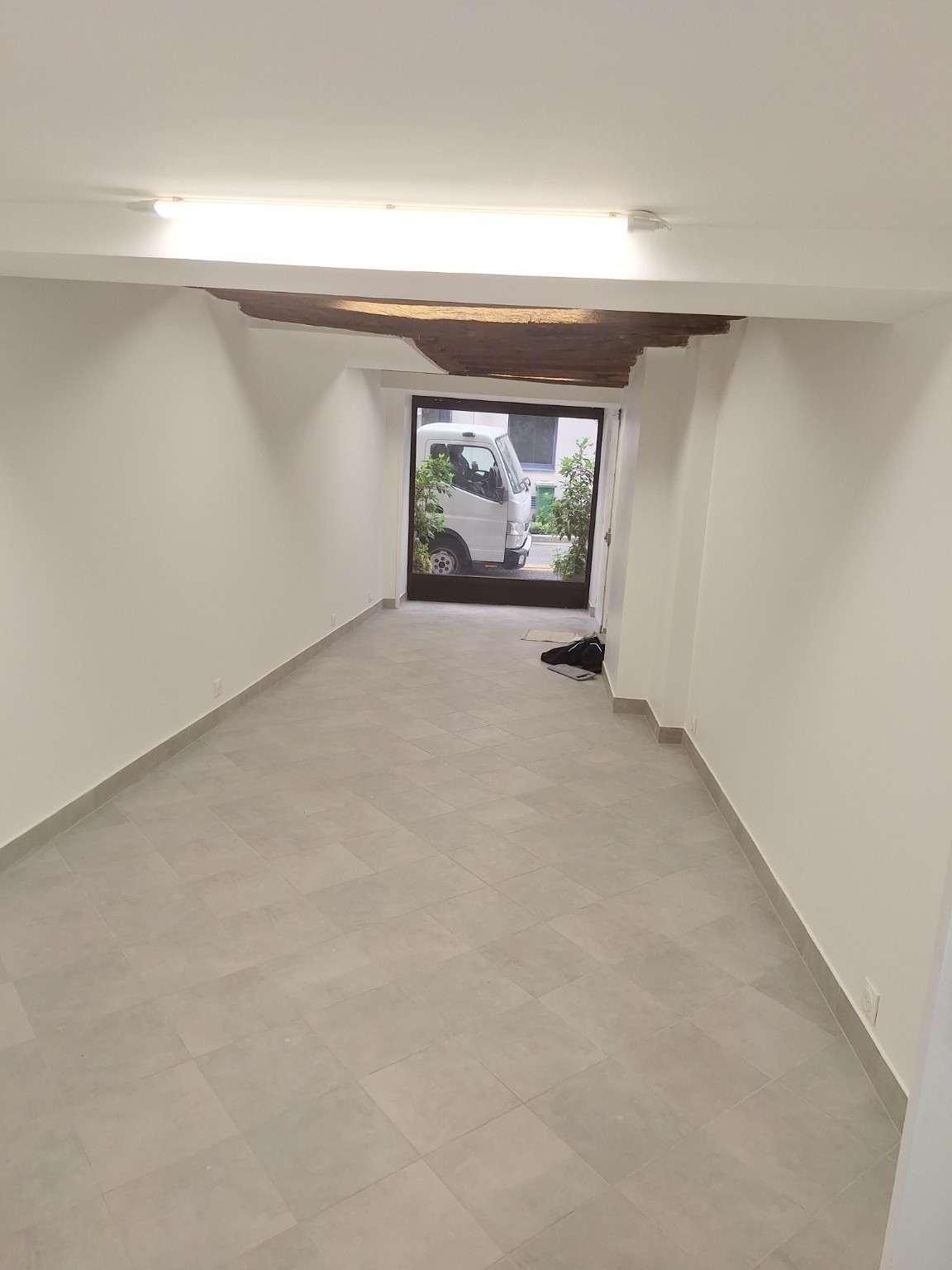 Grande pièce rénovée avec piliers et carrelage
