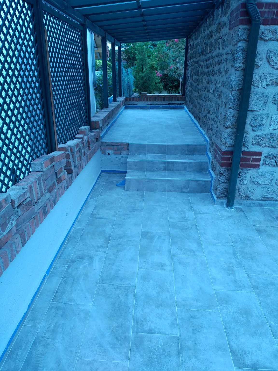 Terrasse extérieure carrelée sous pergola