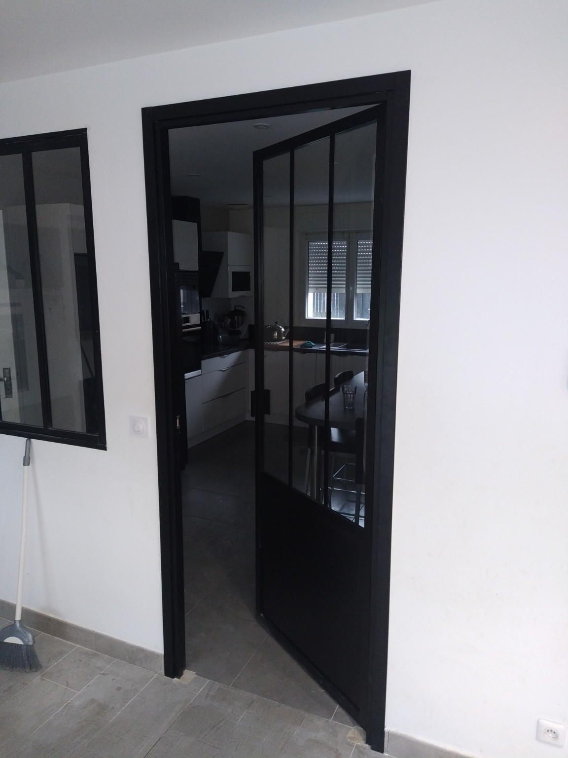Porte verrière noire entre deux pièces