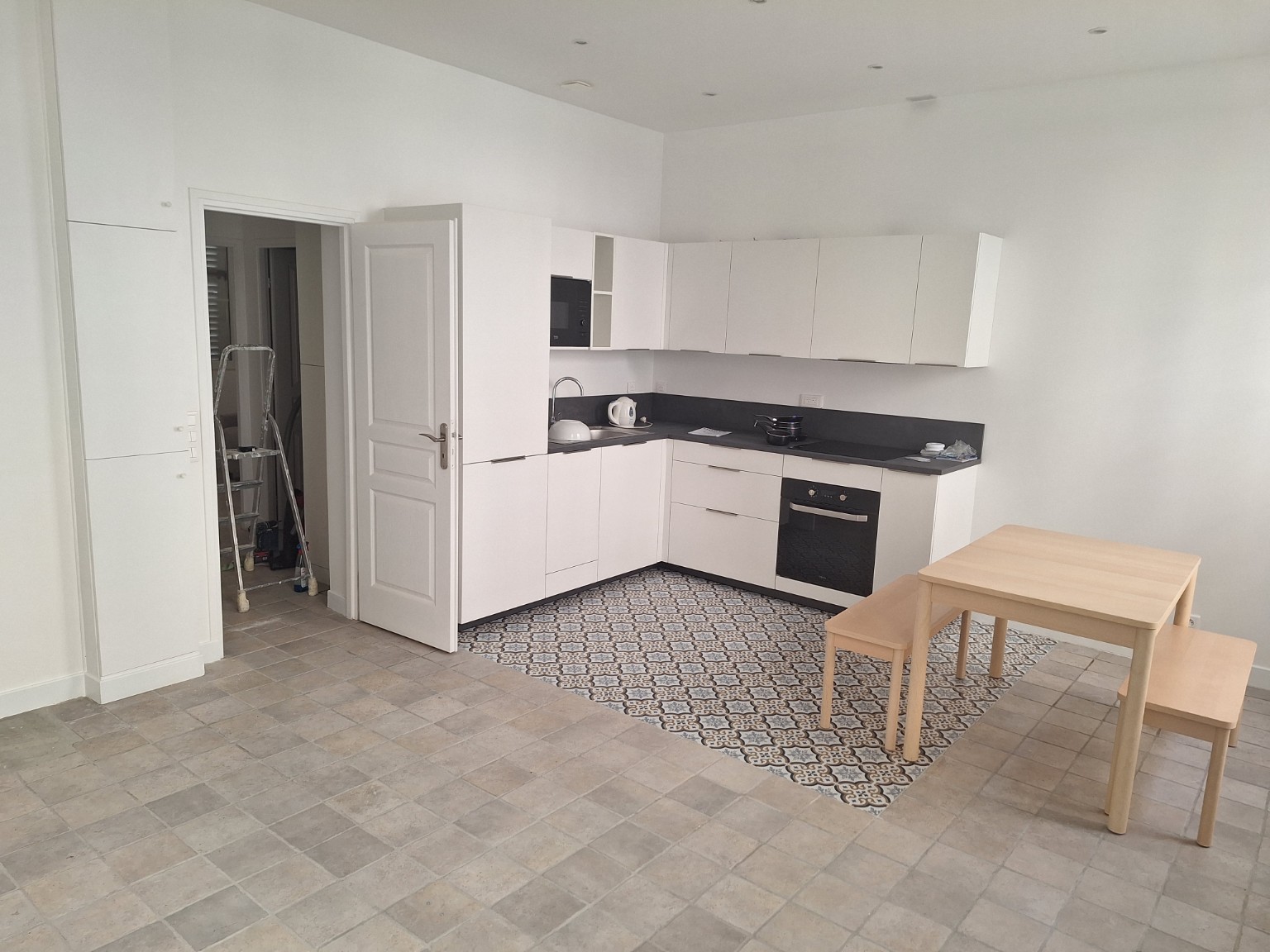Cuisine blanche ouverte avec carrelage décoratif