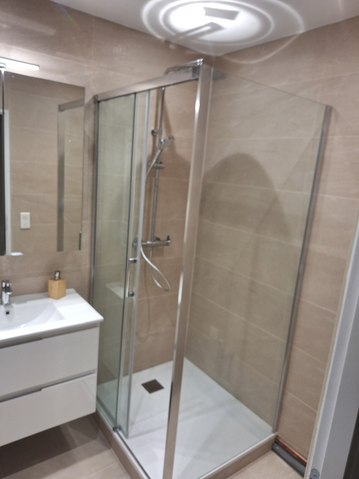 Douche vitrée avec carrelage beige