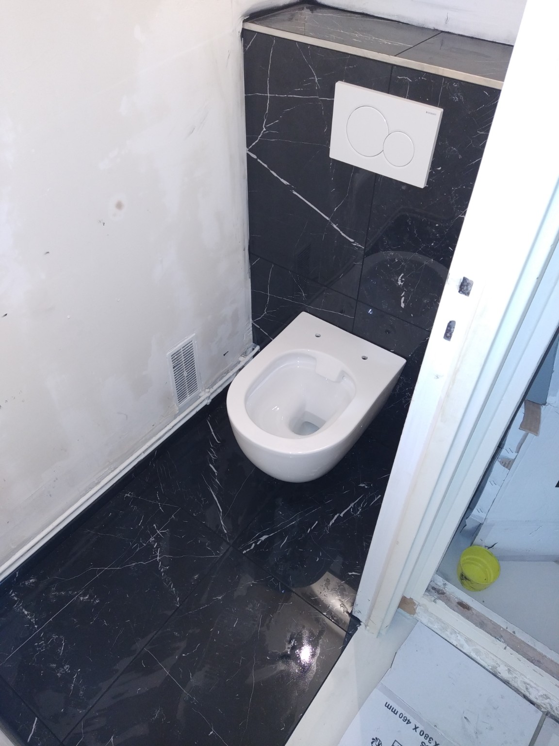 Toilettes suspendues avec carrelage effet marbre noir